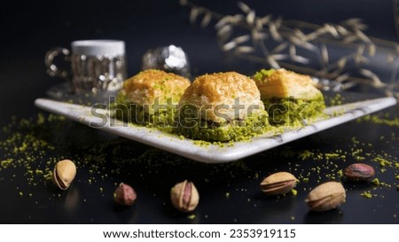 A pleasant break with pistachio baklava and Turkish coffee. Baklava with pistachios, one of the most popular flavors of Turkish cuisine. Combining the flavor of pistachios with Turkish coffee. Royalty-Free Stock Photo #2353919115