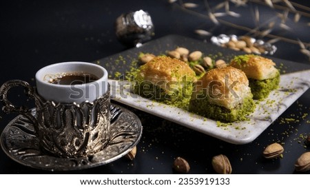 A pleasant break with pistachio baklava and Turkish coffee. Baklava with pistachios, one of the most popular flavors of Turkish cuisine. Combining the flavor of pistachios with Turkish coffee. Royalty-Free Stock Photo #2353919133