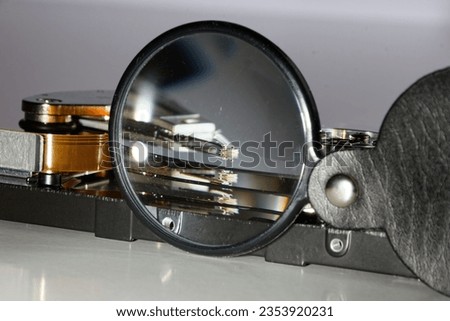 hard drive and magnifying glass, representing the process of searching data, technical view of saving data