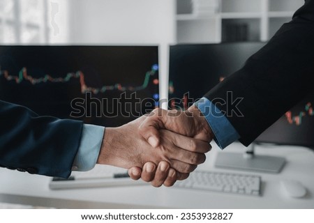 Stock investors shaking hands, business man trading stocks for profit, stock market oscillating graph screen, investment management, analyzing profit trading in stocks.