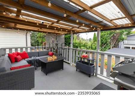 a back porch patio deck with nice furniture and red cushions