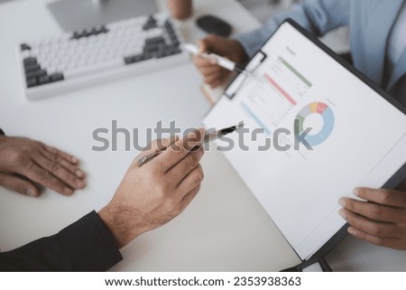Two people looking at datasheets of marketing and sales results, analysis of business results jointly between executives, department heads and employees to brainstorm company sales management. Royalty-Free Stock Photo #2353938363