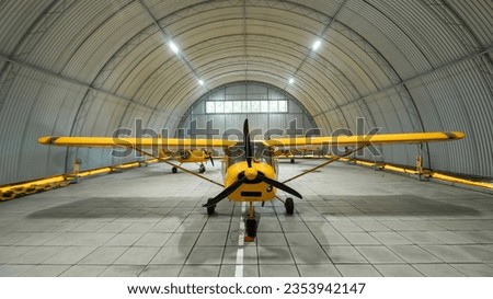 Yellow airplane glider in the hangar.  Royalty-Free Stock Photo #2353942147