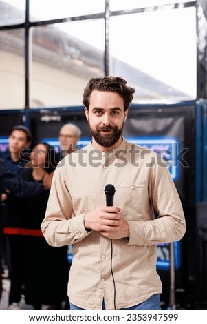 TV journalist holding reporter microphone speaking to camera, broadcasting from Black Friday sales event in shopping mall. Correspondent talking about busy holiday shopping season for news episode Royalty-Free Stock Photo #2353947599