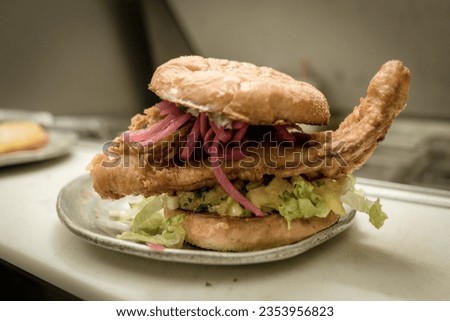 Fried Fish burger with lettuce onions and bun