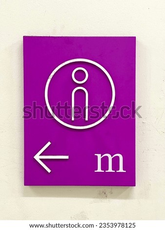 A pink men's restroom sign in front of the restroom