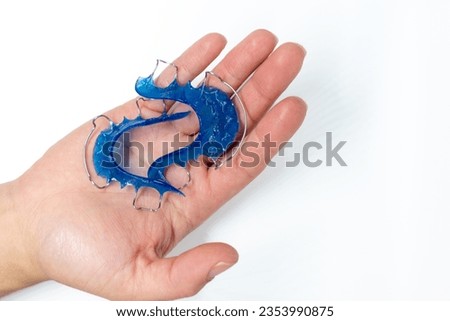 Hawley retainers held by a woman's hands on white background, copy space, selective focus, dental technician concept