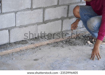 masonry worker make concrete wall by cement block and plaster at construction site                               