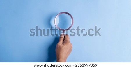 searching, securing, magnifier, icon, man, hand, blue, assurance, family, background. hold a magnifier to searching or find something at blue background. not has icon and symbolic isn't show.