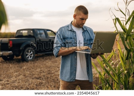 A man is using laptop in te field.