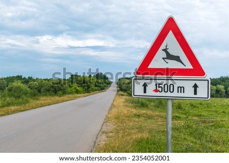 European Deer crossing road traffic sign, Deer Xing in nature. Selective focus.