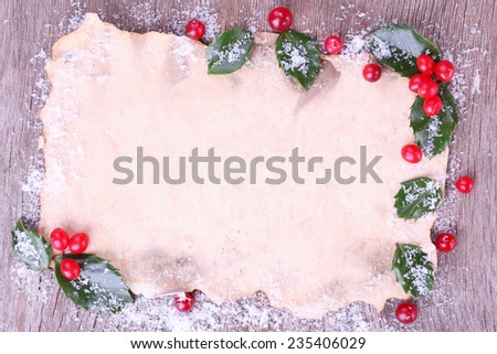 Empty paper with European Holly (Ilex aquifolium) with berries on wooden background