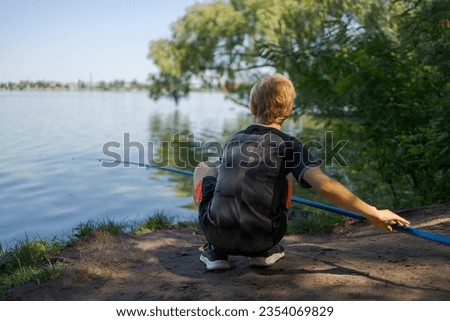 The boy prepared to hook the fish. Sport fishing on the river in summer.