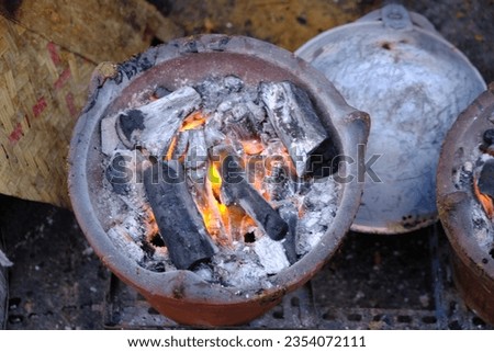 coals smoldering in the brazier. wood fuel. Indonesian traditional cookware. arang.  Royalty-Free Stock Photo #2354072111