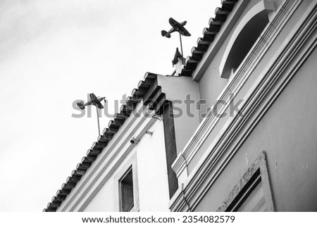 Airplane shaped weather vanes in a building in Lagos. Monochrome picture.