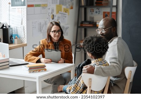 Teacher having meeting with parent of schoolboy Royalty-Free Stock Photo #2354102397