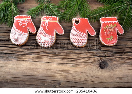 close-up still-life of of fir branches and cookies in the shape of mittens on magic Christmas holiday on background wooden boards studio