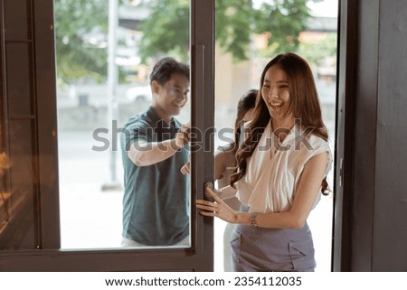 Group of Asian teenagers entering a bakery shop together. Man and women visiting a cafe with smile Royalty-Free Stock Photo #2354112035