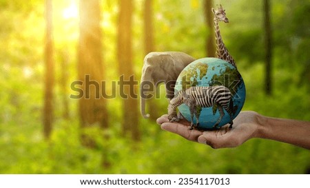 Human hand showing wildlife animal and earth. World Animal Day concept Royalty-Free Stock Photo #2354117013