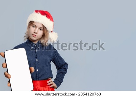 Portrait of pretty young girl Santa holding smartphone with blank empty white screen display