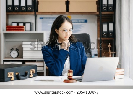 Beautiful asian woman lawyer working and gavel, tablet, laptop in front, Advice justice and law concept.

