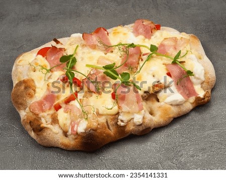 tasty italian pizza with bacon and chicken on a gray background