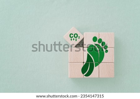 Carbon ecological footprint symbols with green leaves, reduce co2 on wooden cube blocks. eco friendly, zero emission concept.  Sustainable development. Environmental and climate change concept Royalty-Free Stock Photo #2354147315