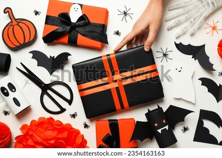 Halloween paper mockups, gifts and hand on white background, top view