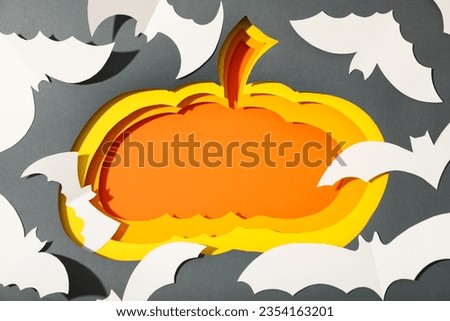 Paper pumpkins and bats on gray background, top view