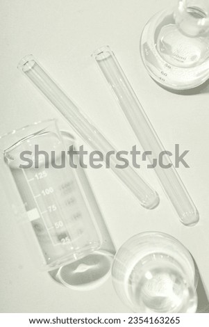 Glass flasks and test tubes on white background, top view.