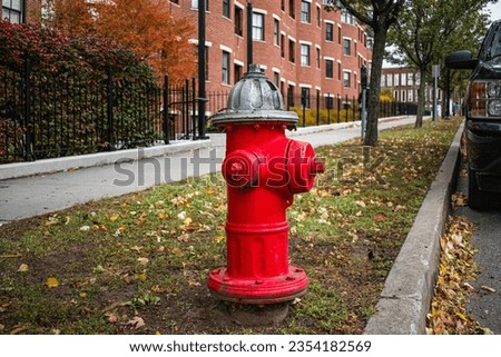 Silver-topped traditional red American style fire hydrant outside a modern housing block on College Street, Burlington, Vermont  Royalty-Free Stock Photo #2354182569