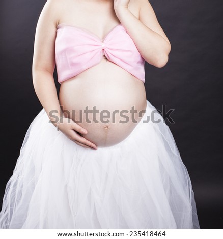 A pregnant mother in black background