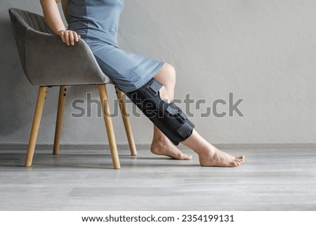 Female leg in knee brace. Injury, medicine, arthritis and meniscus diseases concept. Royalty-Free Stock Photo #2354199131
