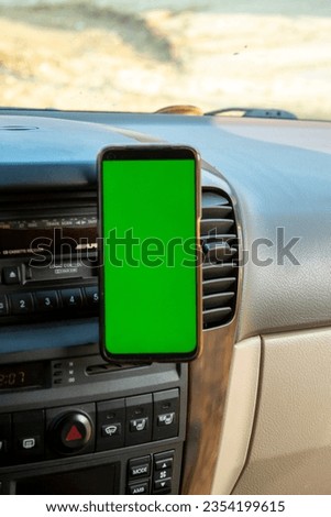 A mobile phone with a green screen in the car. Smartphone.