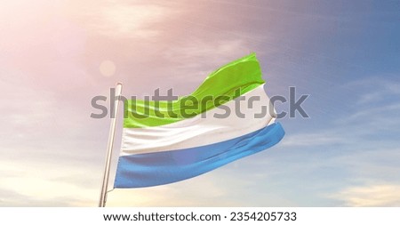 Sierra Leone national flag waving in beautiful sky.