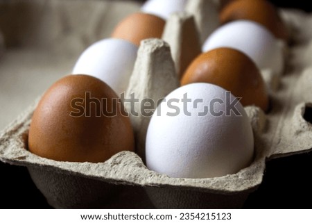 White and brown eggs in a carton box. Selective focus.