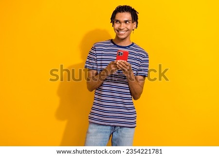 Photo of cheerful man wear trendy clothes hand hold modern device look interesting offer empty space isolated on yellow color background