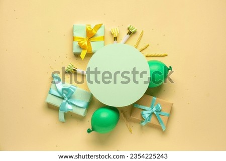 Frame made of different party decor and greeting card on pale yellow background