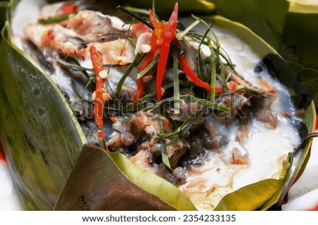 a photography of a plate of food with a banana leaf wrapped in it, globe artichoken in a banana leaf with a side of rice.
