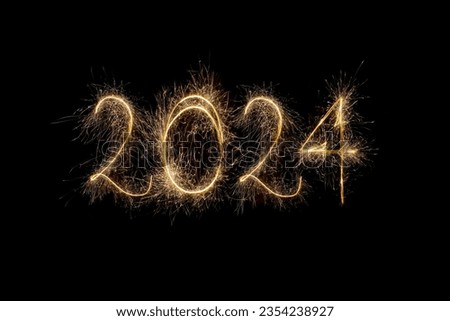 Happy New Year 2024. Number 2024 written sparkling sparklers isolated on black background with copy space for text. Glowing, creative overlay template for holiday greeting card or banner design Royalty-Free Stock Photo #2354238927