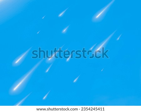 Meteor shower on a blue background. Shooting stars in a clear sky in the light of the sun. Falling meteorites in the daytime.