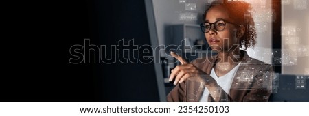 Young Black woman working in office and digital technology concept. Wide angle visual for banners or advertisements.