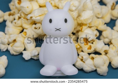 illustration of children's toys with their mouths tightly closed on the popcorn snacks behind them