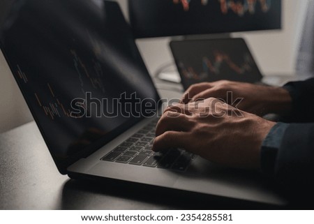Person typing on laptop keyboard keys, stock investor businessman trading stocks, stock market analysis for profitable trading, cryptocurrency investment. Concept of investing in stocks.