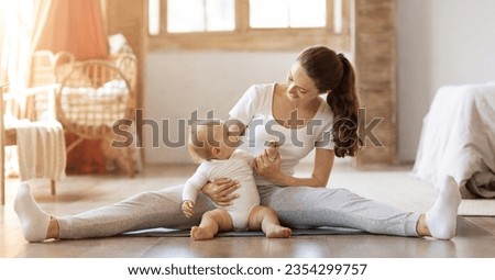Mom and child fitness. Happy athletic young mother training stretching with her little baby toddler at home. Mom doing regular workout on yoga mat with cute blonde infant son, panorama