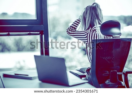 Stressed woman in the office. Depressing colors of photo.