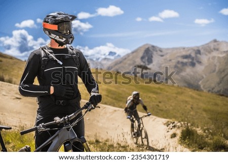 Chilling MTB Biker in the mountains. Relaxed cyclist. Alps.