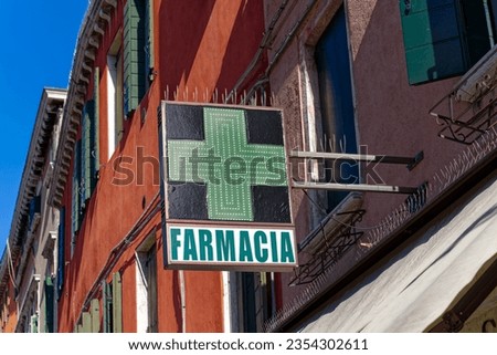 Close-up of green cross led sign of pharmacy at Italian City of Venice on a sunny summer day. Photo taken August 7th, 2023, Venice, Italy.