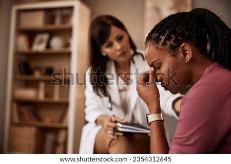An African-American female patient having a hard period in life and talking with a female psychologist. Royalty-Free Stock Photo #2354312645