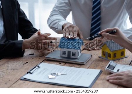 Close up focus on small house model standing on table with clients signing contract agreement with real estate agent, purchasing own dwelling apartment, professional service concept.